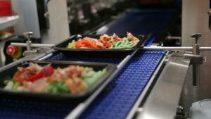 a couple of trays of food on a stove